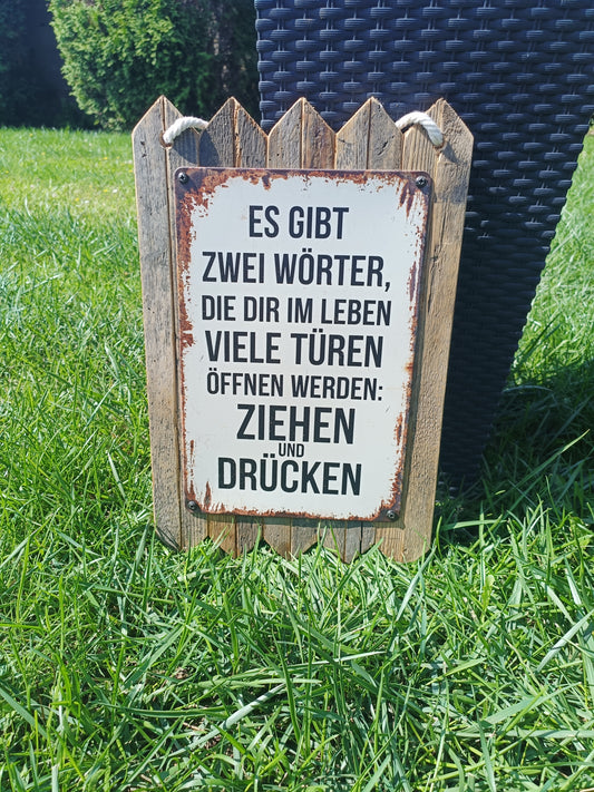 Metal sign "There are 2 words that open many doors for you: Pull and push, on old wood